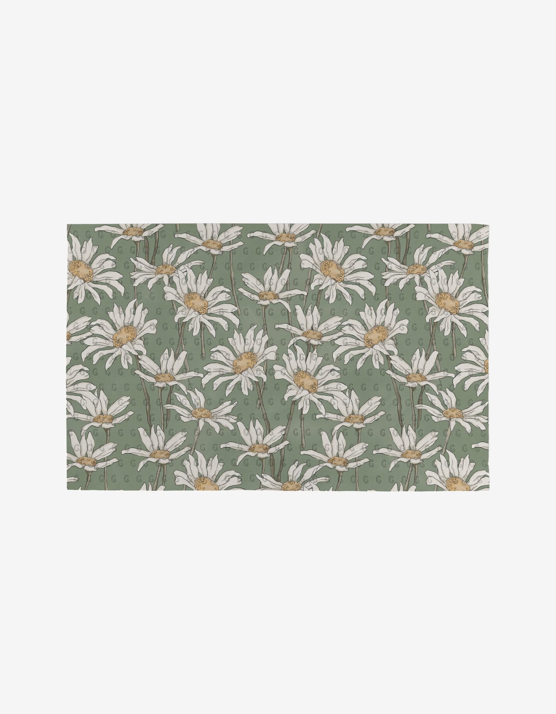 The Springtime rug by Aubrey Fairchild is rectangular, made from post-consumer recycled materials, and features white daisies with yellow centers and green stems on a muted green background.