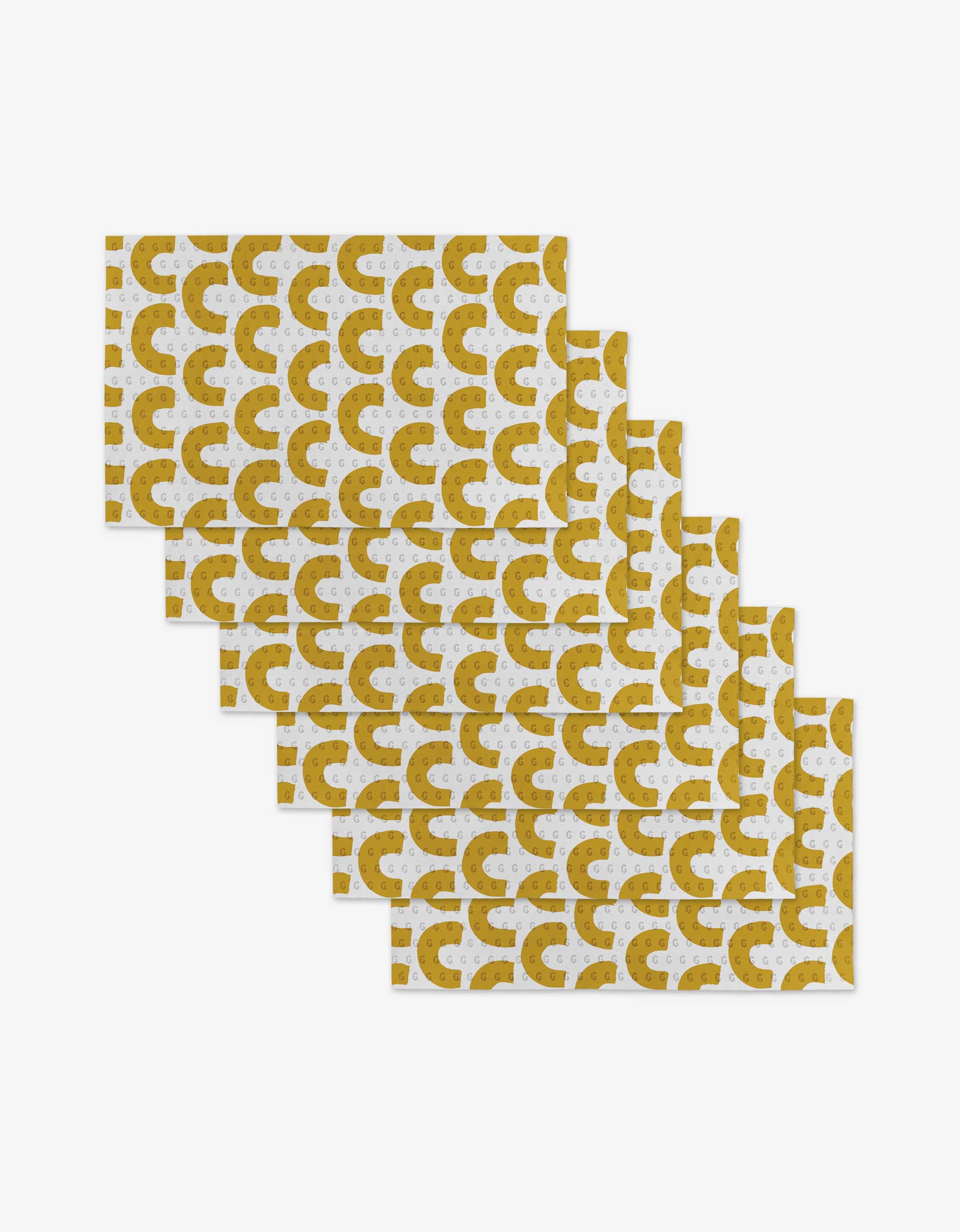 Six GEOMETRY Sunny Hills rectangular Not Paper Towels, featuring a gold and white semicircle pattern, are staggered and overlapping on a white background—an eco-friendly choice made from post-consumer recycled materials.