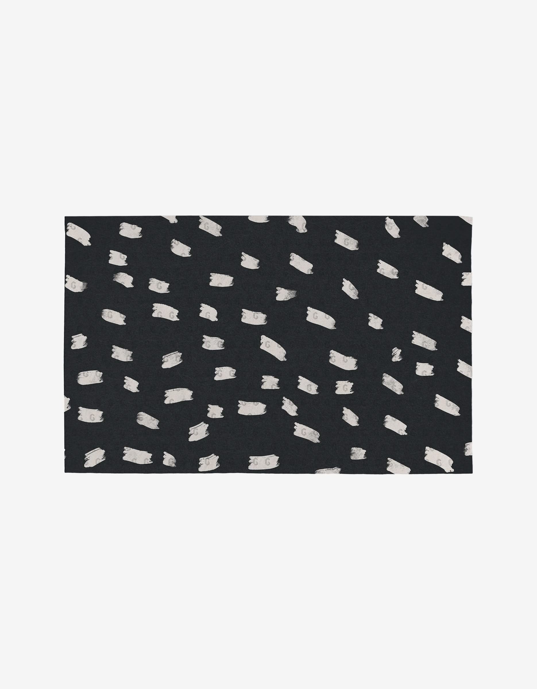 The Tess And Dark rug by GEOMETRY is a rectangular, black eco-friendly rug with an abstract pattern of irregular white brushstrokes, crafted from post-consumer recycled materials.