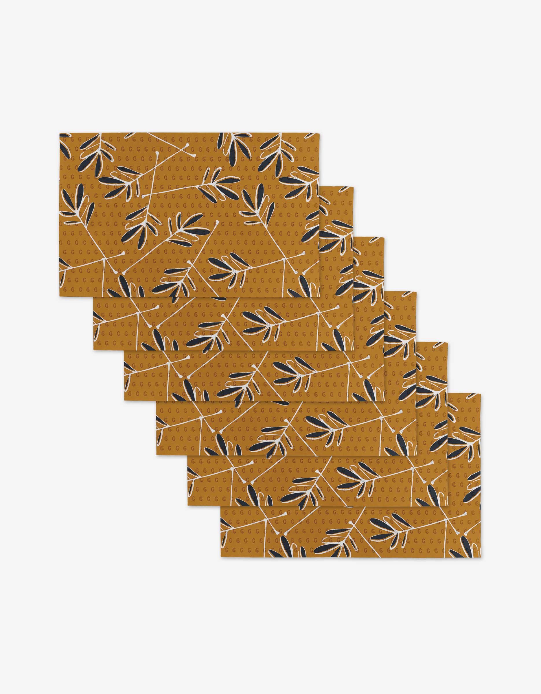 Set of eight Tess rectangular placemats by GEOMETRY, featuring a mustard yellow background with a black and white leafy branch pattern and dotted accents, made from eco-friendly post-consumer recycled materials.