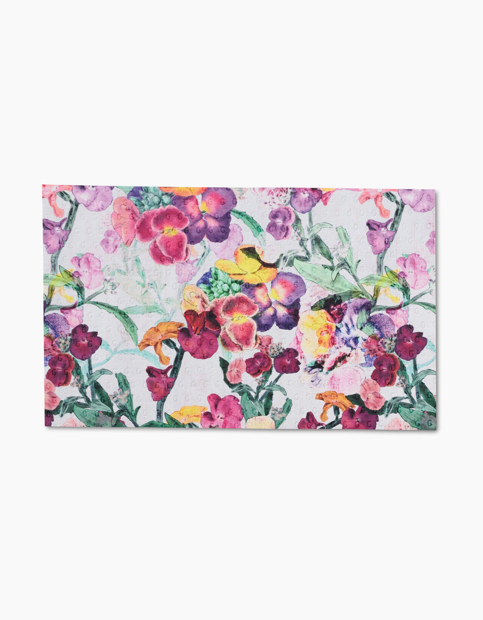 Wallflower by Pascale Dilger features a vibrant abstract floral design with purple, yellow, pink, and green hues on a white background. The densely packed flowers create a lively artistic composition inspired by eco-friendly towels.