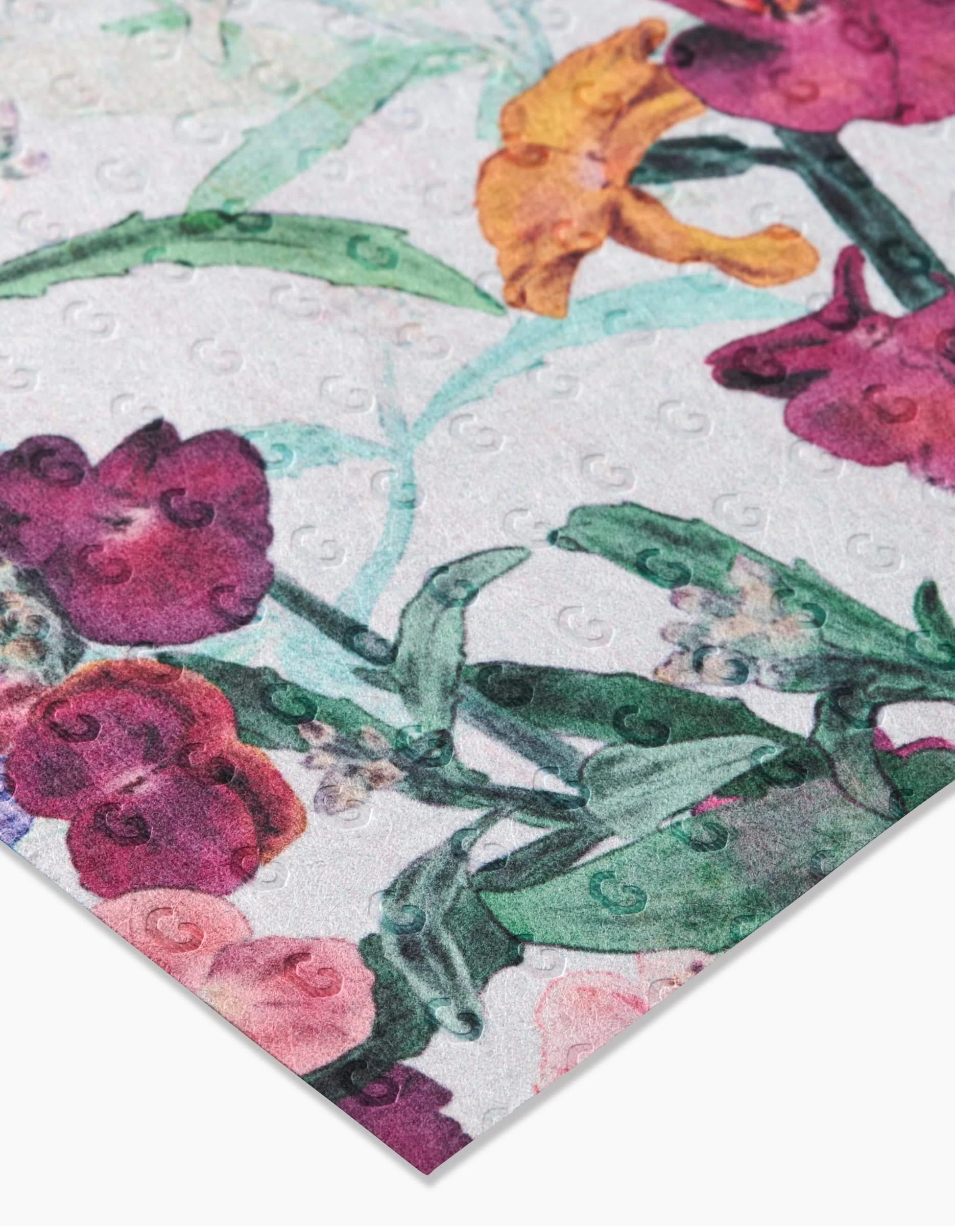 A close-up shows Wallflower, reusable kitchen towels by Pascale Dilger, featuring a colorful floral print in pink, purple, and orange on white with raised circular textures that highlight their quality and sustainability.