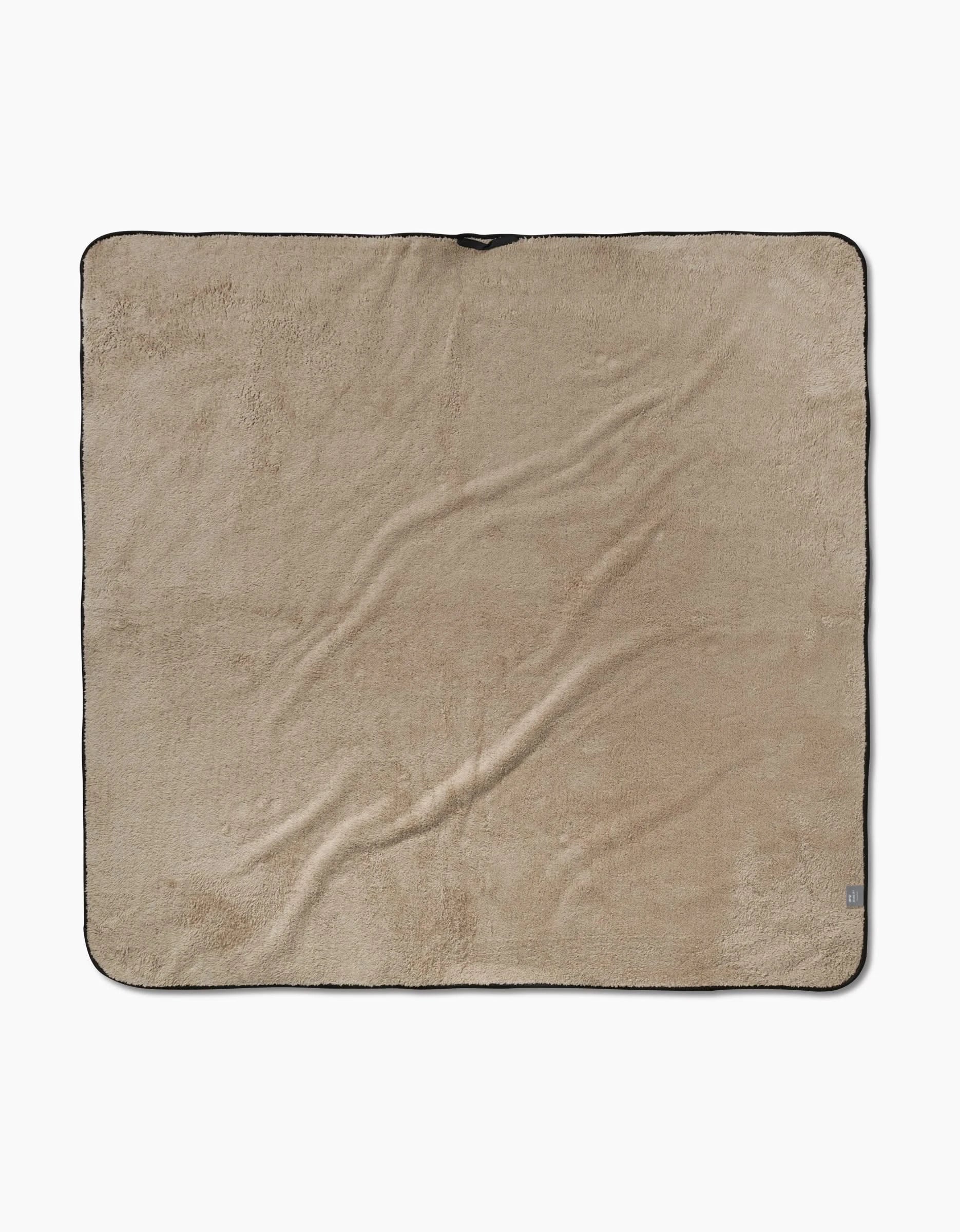 The Geometry Sweet Daisies dog towel is large, square, and beige with black trim, made of ultra-absorbent microfiber for a soft feel. Shown laid flat on a white background.