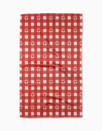 The Amorcito Gingham tea towel by Geometry features a red and white gingham pattern with small white hearts in some red squares, made from Geoweave™ fabric.