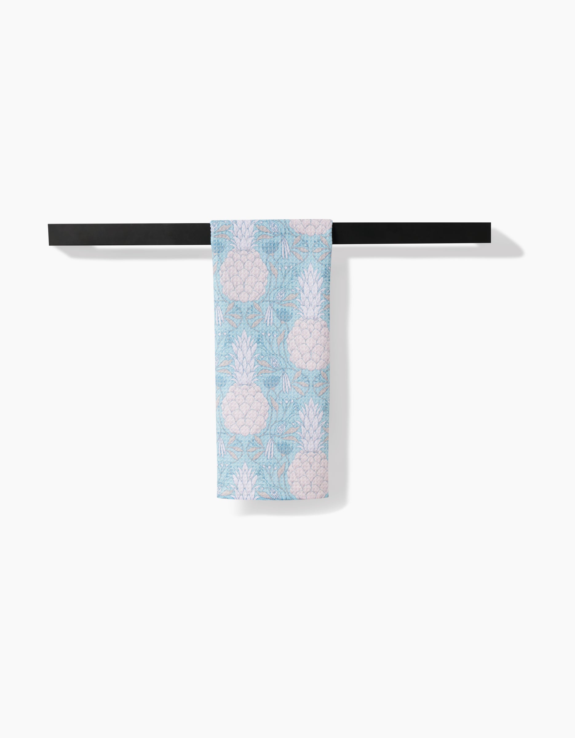A light blue and white Andre tea towel by Amy MacCready, featuring a playful pineapple pattern and crafted from Geoweave fabric, hangs neatly on a black towel bar against a plain white background.