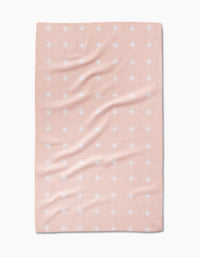 The Amy MacCready Aveline blanket is rectangular, light pink, made from Geoweave fabric with a subtle texture, and features evenly spaced small white dots. Its shown spread flat with gentle folds and wrinkles.