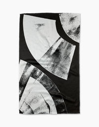 The Skye Walker Black Graphite Shift is a black ultra-absorbent tea towel with bold abstract white and gray geometric shapes and textured brushed patterns, offering a modern, artistic look.