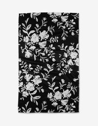 The Danelys Sidron Botanical Silhouettes Charcoal is a black rectangular Geoweave fabric featuring a white floral pattern of scattered flowers and leaves, made from recycled materials.