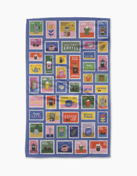 The Brewed By Mail tea towel from Cottonflower Studio features coffee-themed postage stamp designs and phrases like Latte and But First, Coffee. Made from recycled materials, this ultra-absorbent towel brightens your kitchen routine.