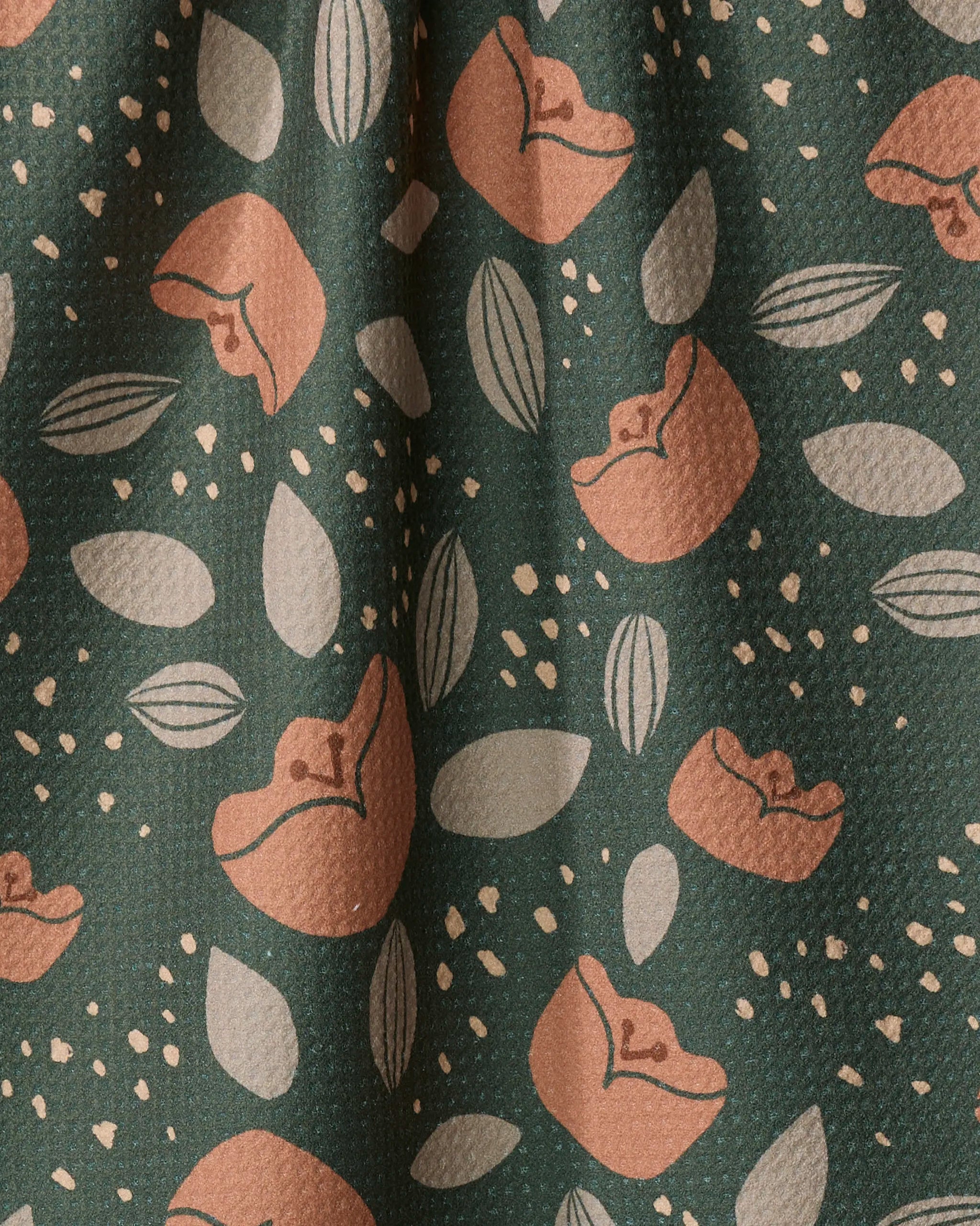 The Cali Sun towel by Amberleigh Adoff features green textured fabric with a modern, nature-inspired print of abstract peaches and light leaves—creating a quick-drying kitchen tea towel with contemporary style.