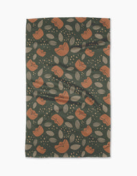 Cali Sun by Amberleigh Adoff features a dark green background with orange flowers, beige leaves, and dots. This ultra-absorbent, slightly textured towel is stylish and functional—perfect for any kitchen.
