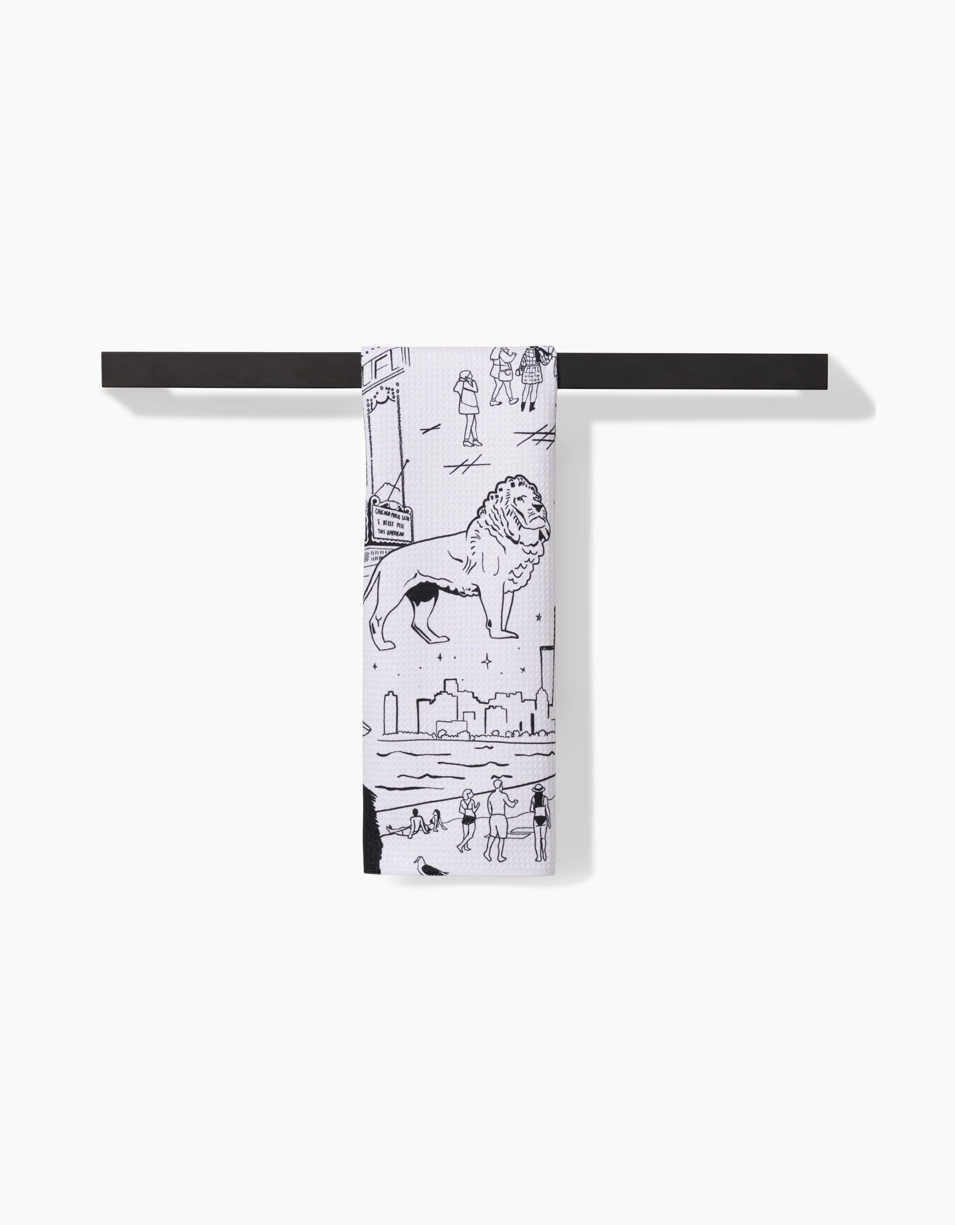 The Elisabeth Wing Chicago tea towel, crafted from Geoweave fabric, showcases black line art of a lion and city skyline, and hangs neatly on a sleek black towel bar against a white background.