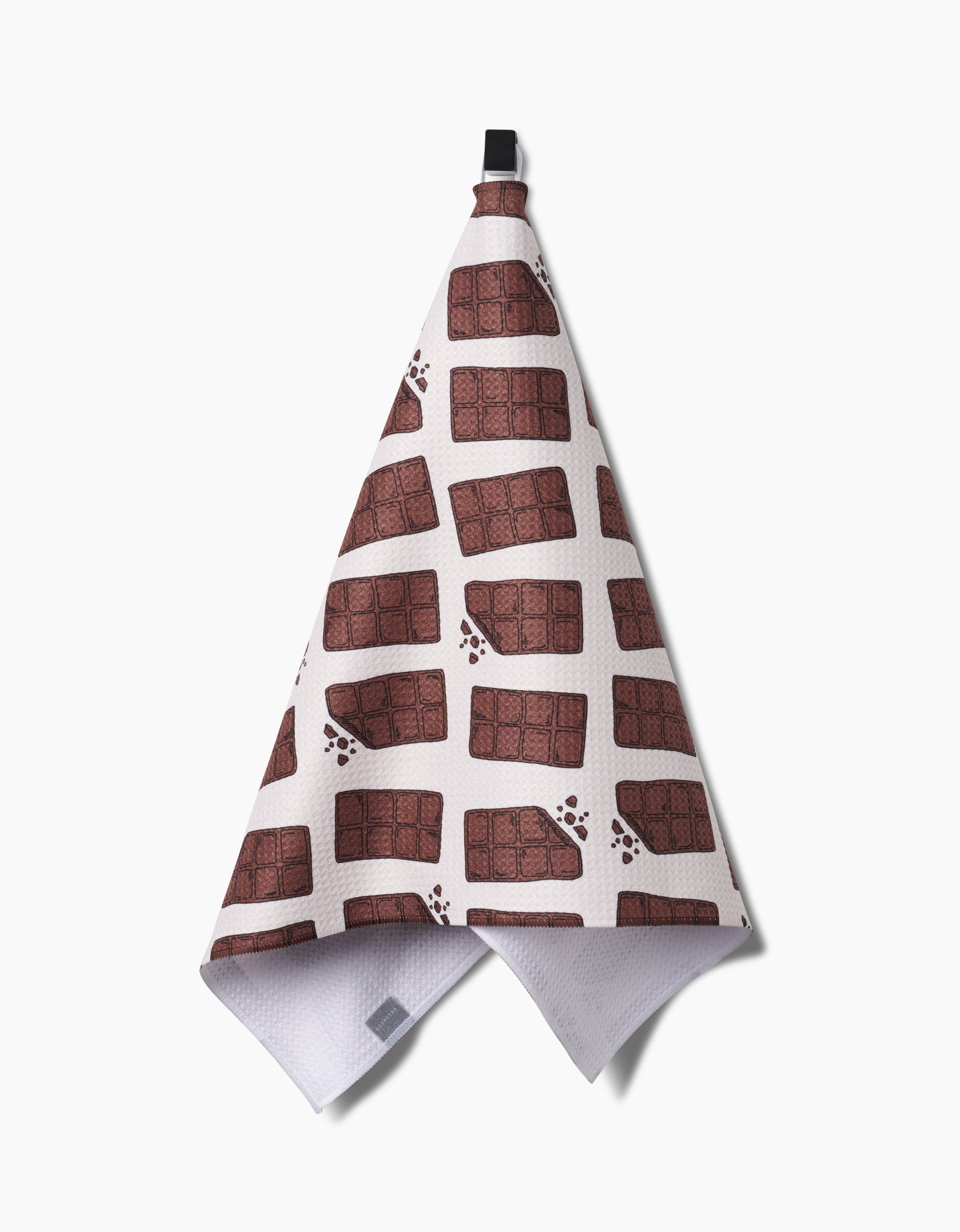 The Chocolate Everything tea towel by Amy Droubay, made from recycled materials, features a brown chocolate bar pattern with smudges and hangs by a black loop against a plain white background.