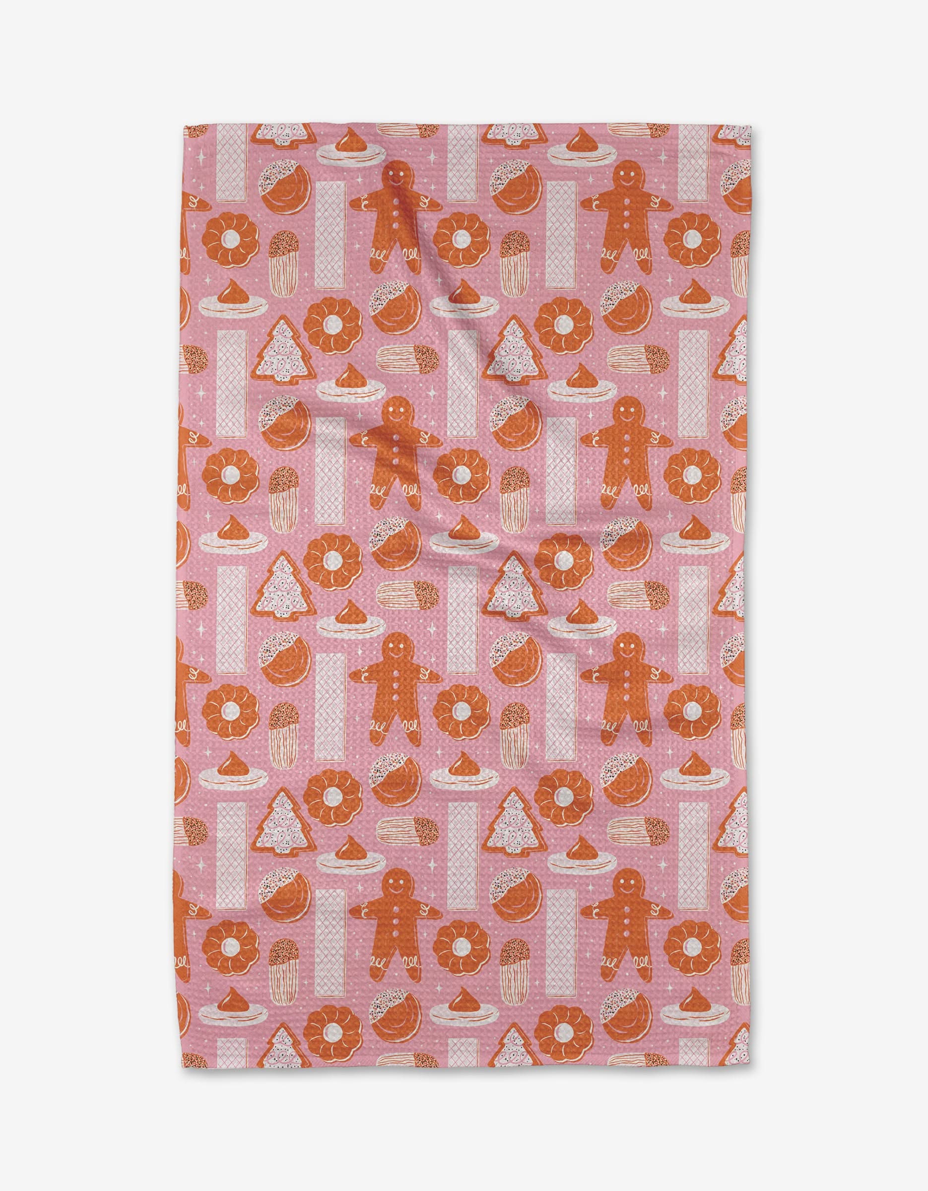 The Christmas Cookies kitchen towel by Megan Roy features gingerbread men, donuts, cupcakes, Christmas trees, and Santa hats in orange, white, and red on pink. Made from recycled materials for a sustainable touch.