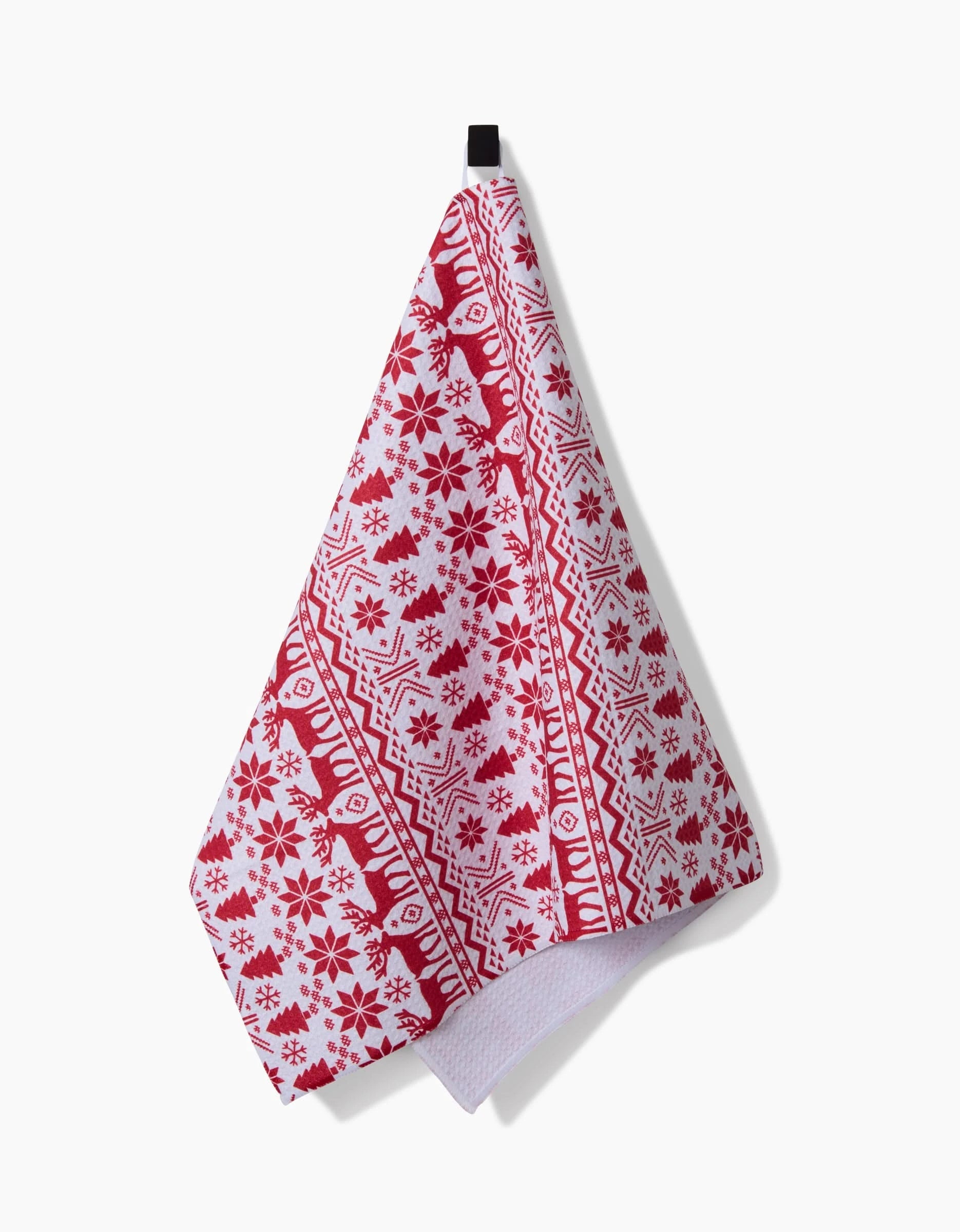 The Hufton Studio Christmas Jumper tea towel features a festive red and white snowflake, reindeer, and geometric pattern, and hangs from a black loop against a white background.