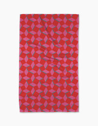 The Geometry Circus Stand Tea Towel features a red rectangular design with pink and blue interlocking cubes for a 3D optical illusion, crafted to eco-friendly standards for both style and sustainability.