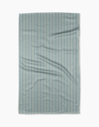 The Clean Slate tea towel by Susan Heid is rectangular, made from recycled materials, with thin blue and white vertical stripes and a slightly wrinkled texture, shown against a white background.