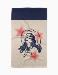 The Geometry Cowgirl Summer tea towel features an illustrated woman in a cowboy hat and scarf with three red stars, set on beige Geoweave fabric with a navy blue top border.