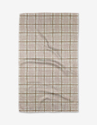 The Studio Jeannot Crossover tea towel features a rectangular Geoweave fabric with brown and red grid lines on a light background, displayed flat with slight wrinkles. This eco-friendly textile blends style with sustainability.