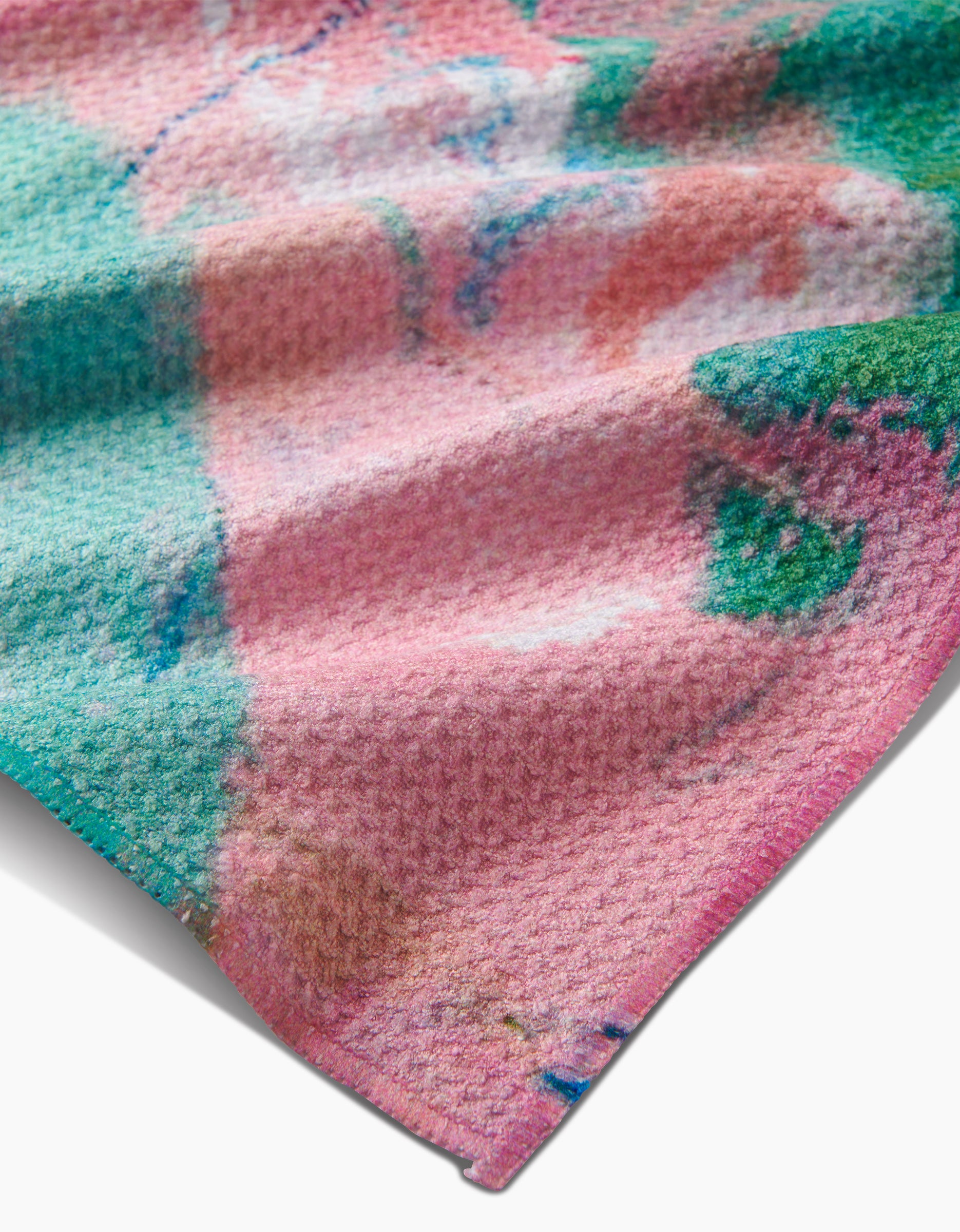 A close-up of the Daughter Tea Towel by Sarah Holden, crafted from Geoweave fabric with a colorful abstract pattern in pink, green, and teal, revealing its soft texture and gentle folds.