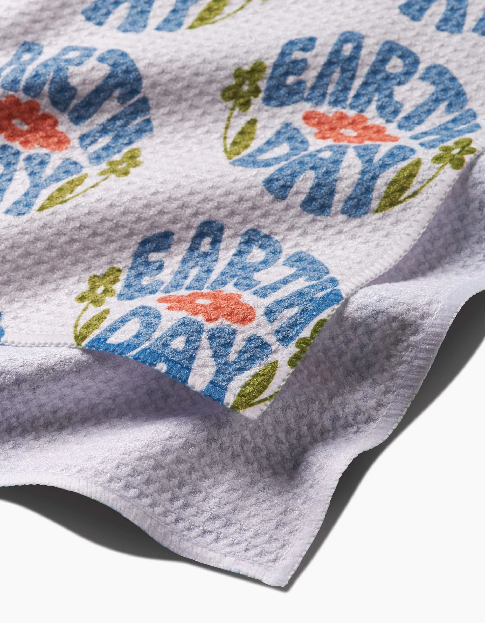 The Kayla Ann Earth Day Stamp dish towel is stylish and absorbent, featuring a unique design—perfect for drying dishes or adding flair to your kitchen.