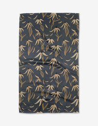 The Echinacea tea towel by Katie OShea features a dark blue Geoweave fabric with cream, tan, and brown botanical leaves and flowers in a diagonal repeating pattern.