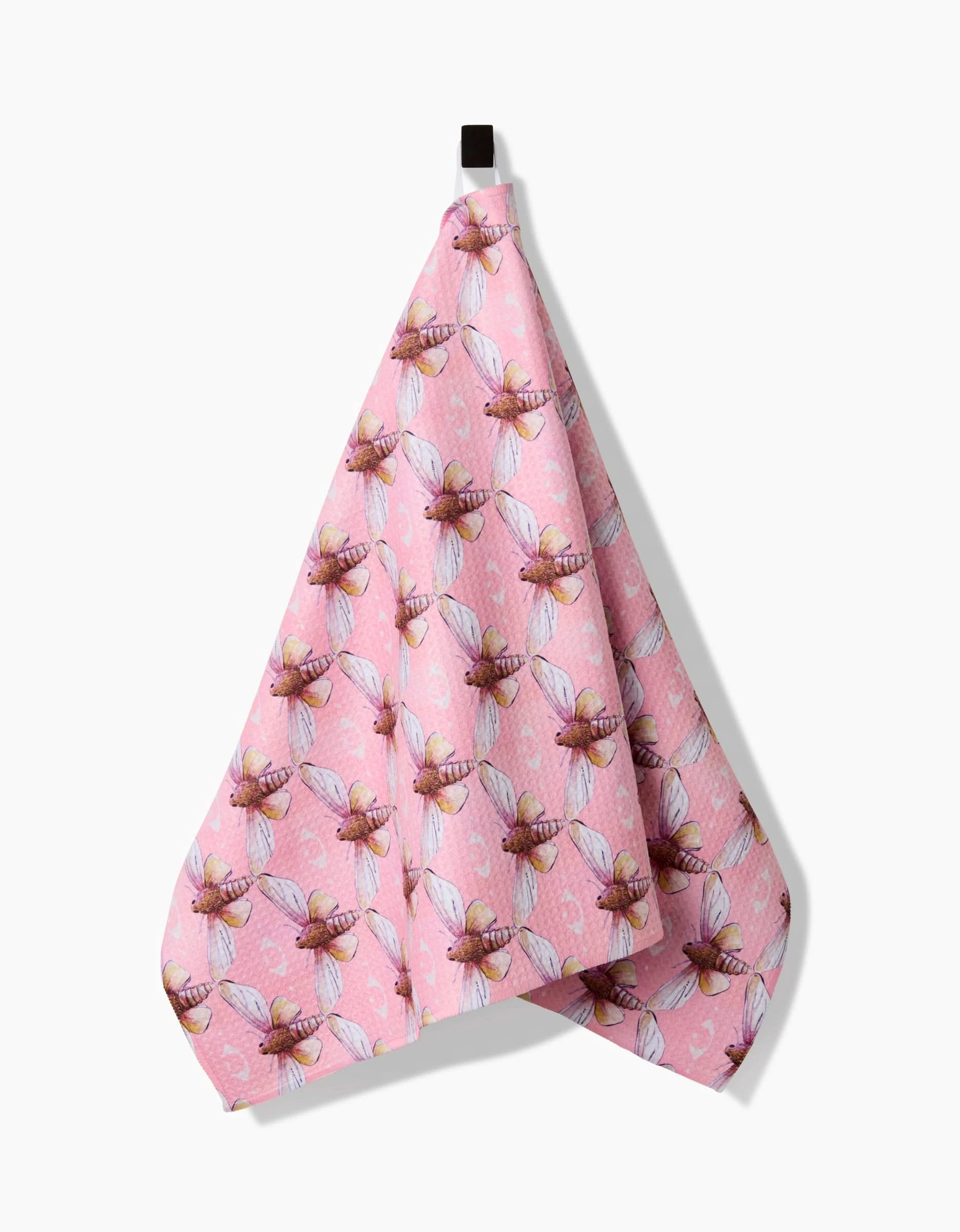 The Echo towel by Maayan Alper-Swan, made from ultra-absorbent Geoweave fabric, features a pink base with a repeating pattern of detailed bees and hangs from a black loop.