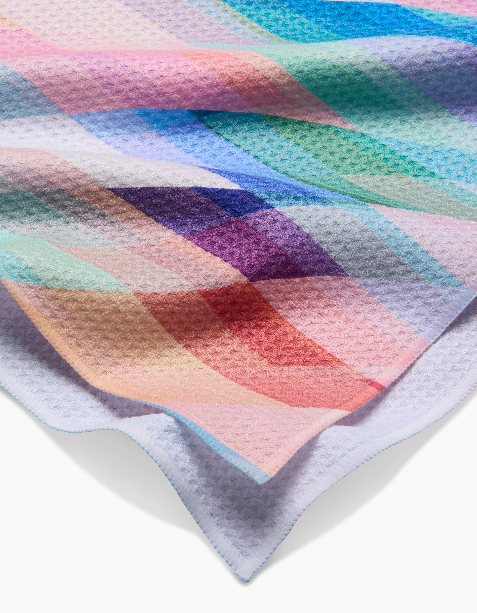 A close-up of the Eventide blanket by Rachel Parker showcases its colorful pastel plaid pattern in pink, blue, green, purple, and tan on a soft Geoweave™ fabric, similar to the Geometry House Tea Towel.