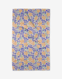 The Elisabeth Wing February tea towel features a colorful floral design with orange, blue, and green flowers on white Geoweave™ fabric. Shown slightly wrinkled against a white background.