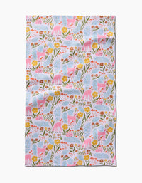 The Fern and Fawn tea towel by Kayla Ann features playful pink deer, yellow flowers, and green leaves on white. Made from recycled materials, it has a slightly wrinkled look and a whimsical, nature-inspired design.