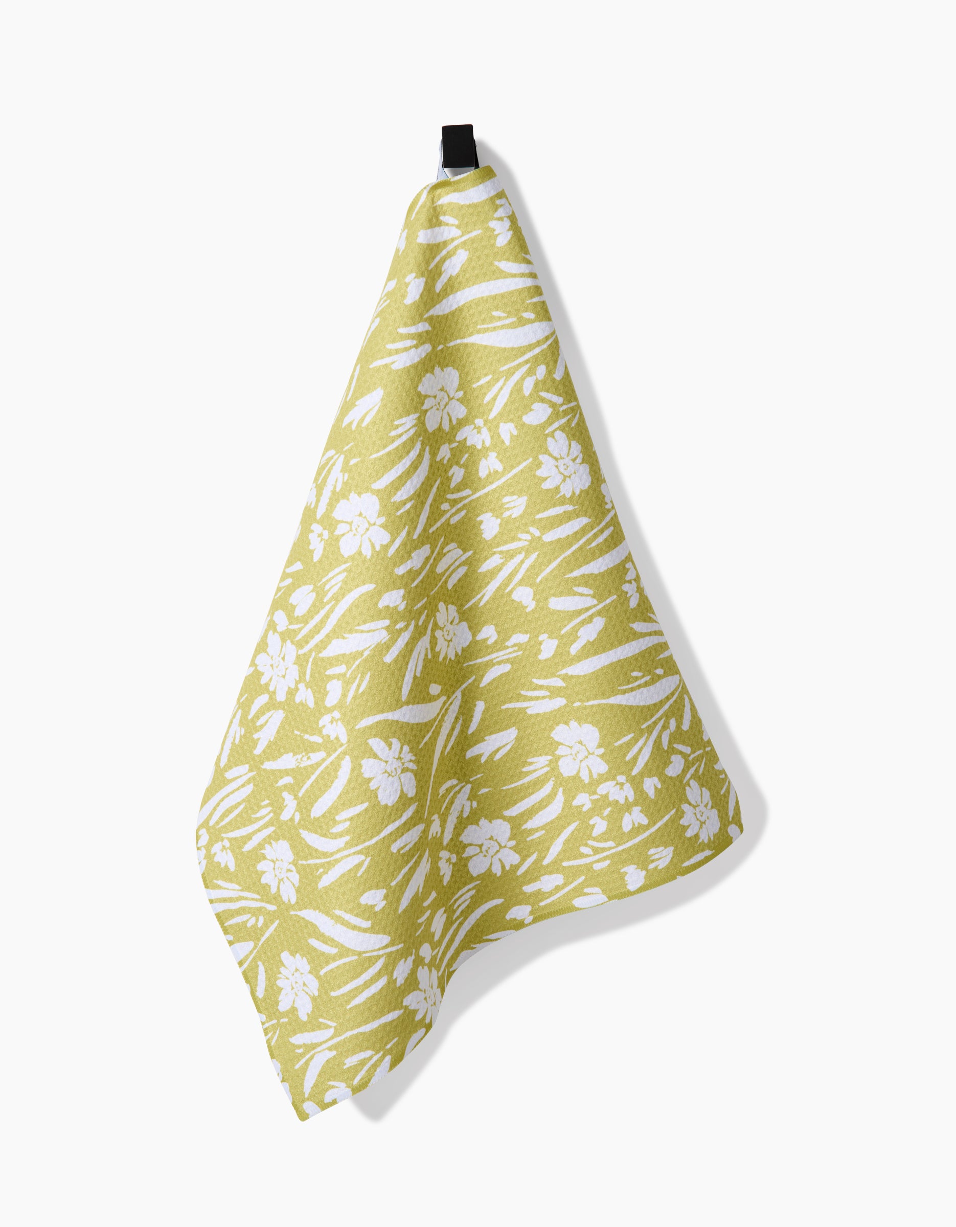 The “Field of Wildflowers” by Ashley Celena, a yellow and white floral-patterned cloth made from ultra-absorbent Geoweave fabric, hangs from a black loop against a plain white background.