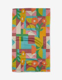 Lisa Nelson’s Floral Geometry tea towel features colorful geometric flowers, leaves, and shapes in orange, yellow, pink, green, and blue on white—crafted from recycled materials for a vibrant eco-friendly touch.