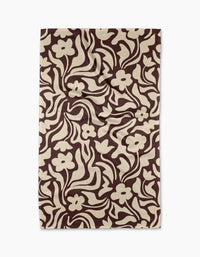 The Gerdadzy Floral Reverie rug is rectangular and features a bold brown and beige abstract floral pattern with swirling lines and stylized flowers, crafted from recycled materials for eco-friendly style.