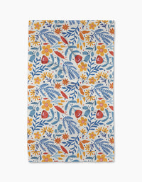 The Folk Flora tea towel by Cottonflower Studio features a colorful floral design—orange, yellow, and red flowers with blue leaves—on white, made from quick-drying recycled materials.