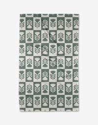 The Green Flower Patch tea towel by Charlie Rowan Designs features a grid of stylized green and white flowers and leaves. Crafted from Geoweave fabric, it blends modern style with superior absorbency.