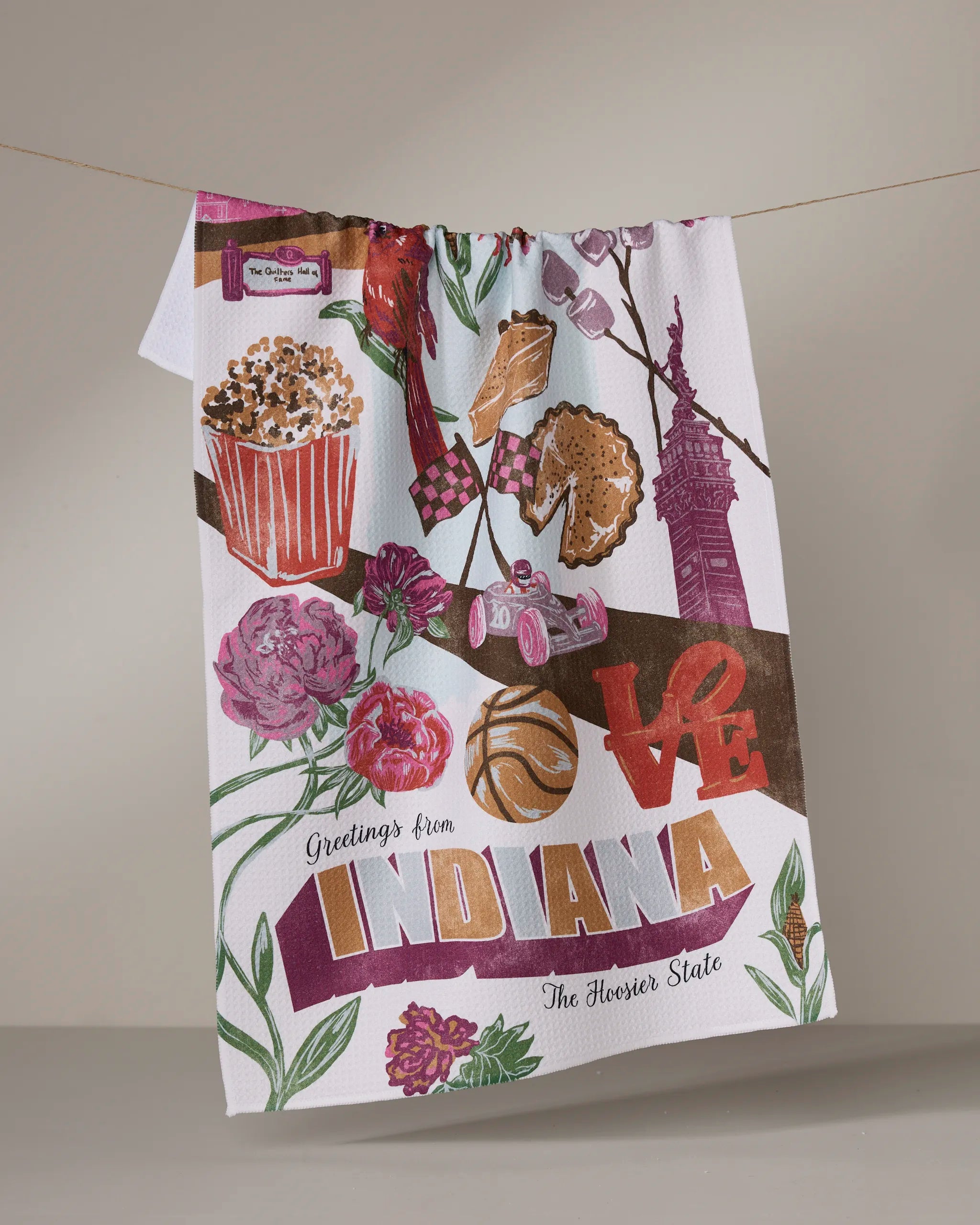 Geometry’s “Greetings From Indiana” tea towel is made from recycled materials and features colorful Indiana icons like popcorn, a race car, basketball, flowers, pie, LOVE, and “Greetings from Indiana, The Hoosier State.”.