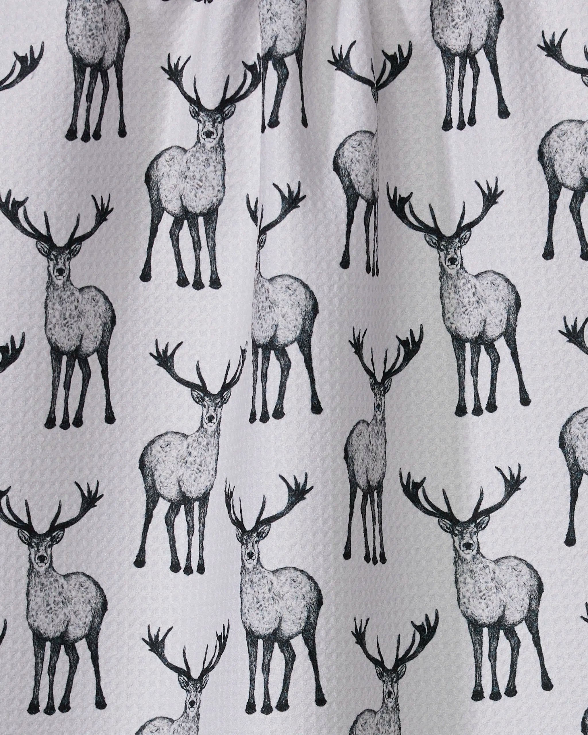 Hartley by Geometry features a black and white standing deer with large antlers in a symmetrical, repeating pattern, printed on an ultra-absorbent tea towel.