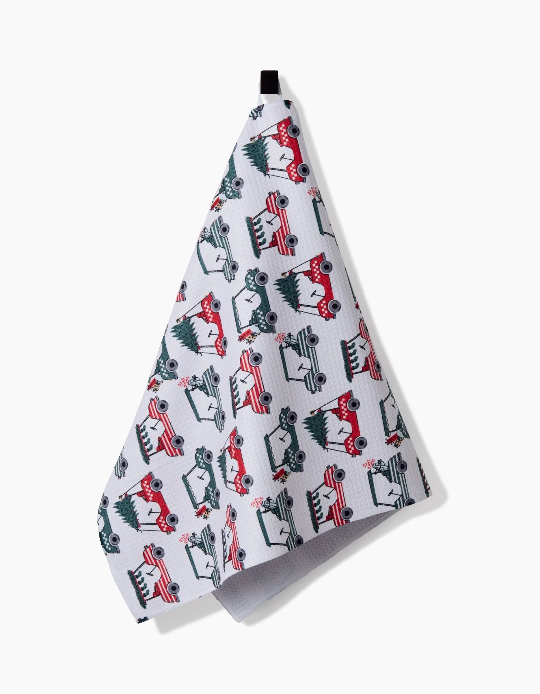 The Holiday Golf kitchen towel by Charlie Rowan Designs features red and green cars with Christmas trees, hangs from a black loop, and is eco-friendly—perfect for festive holiday cheer in your home.