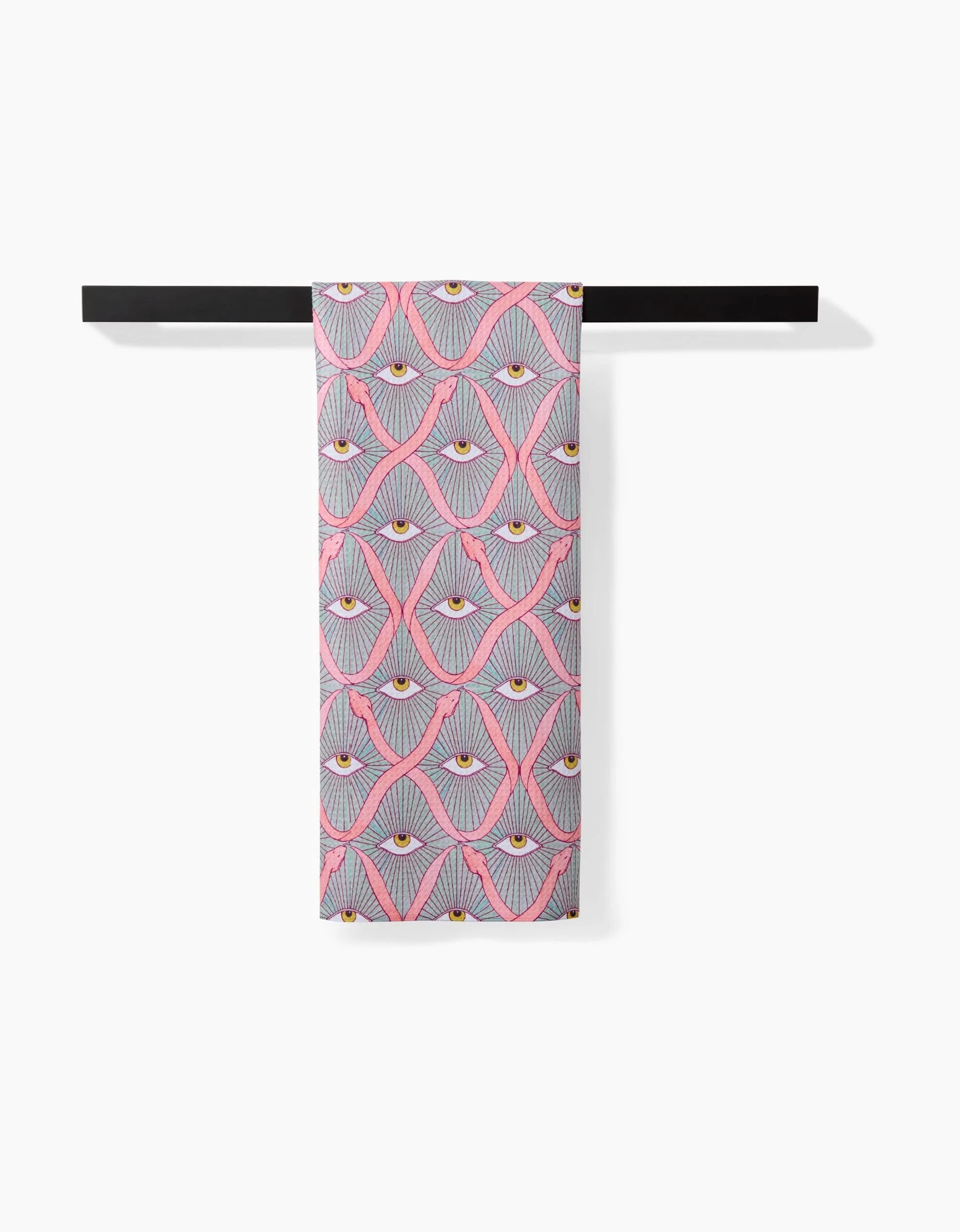 Illusionist by Maayan Alper-Swan is a patterned scarf crafted from recycled materials, showcasing abstract eyes in pink, gray, yellow, and white, neatly folded over a black rod with a white backdrop.