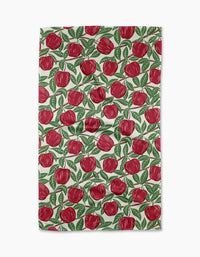 The In the Apple Tree towel by Sarah Daugherty is a rectangular, quick-drying towel with a white background and a repeated red apple with green leaves pattern.