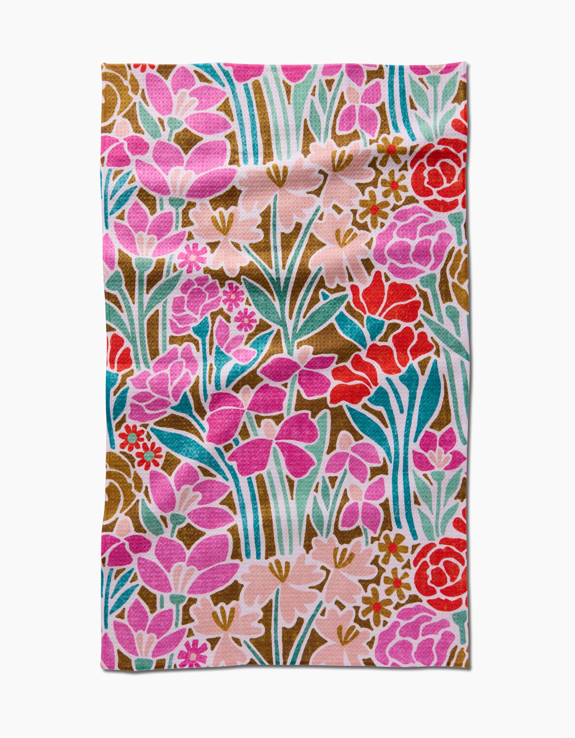 The Amy MacCready Janae tea towel features a rectangular Geoweave fabric with a vibrant floral pattern of pink, red, and purple flowers, green leaves, and stems on a white background. The fabric has a slightly wrinkled appearance.