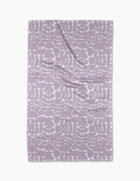 The Lavender Scandi Flowers blanket by Katie OShea, made from recycled materials, showcases a lavender and white floral pattern arranged in rows, displayed flat against a white background.
