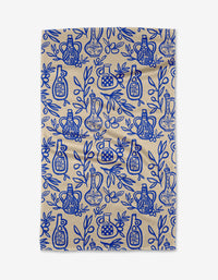 Lisa Nelson’s “Mediterranean Pour” is a beige recycled kitchen towel with a blue pattern of bottles, lemons, and leafy branches in a repeating design.