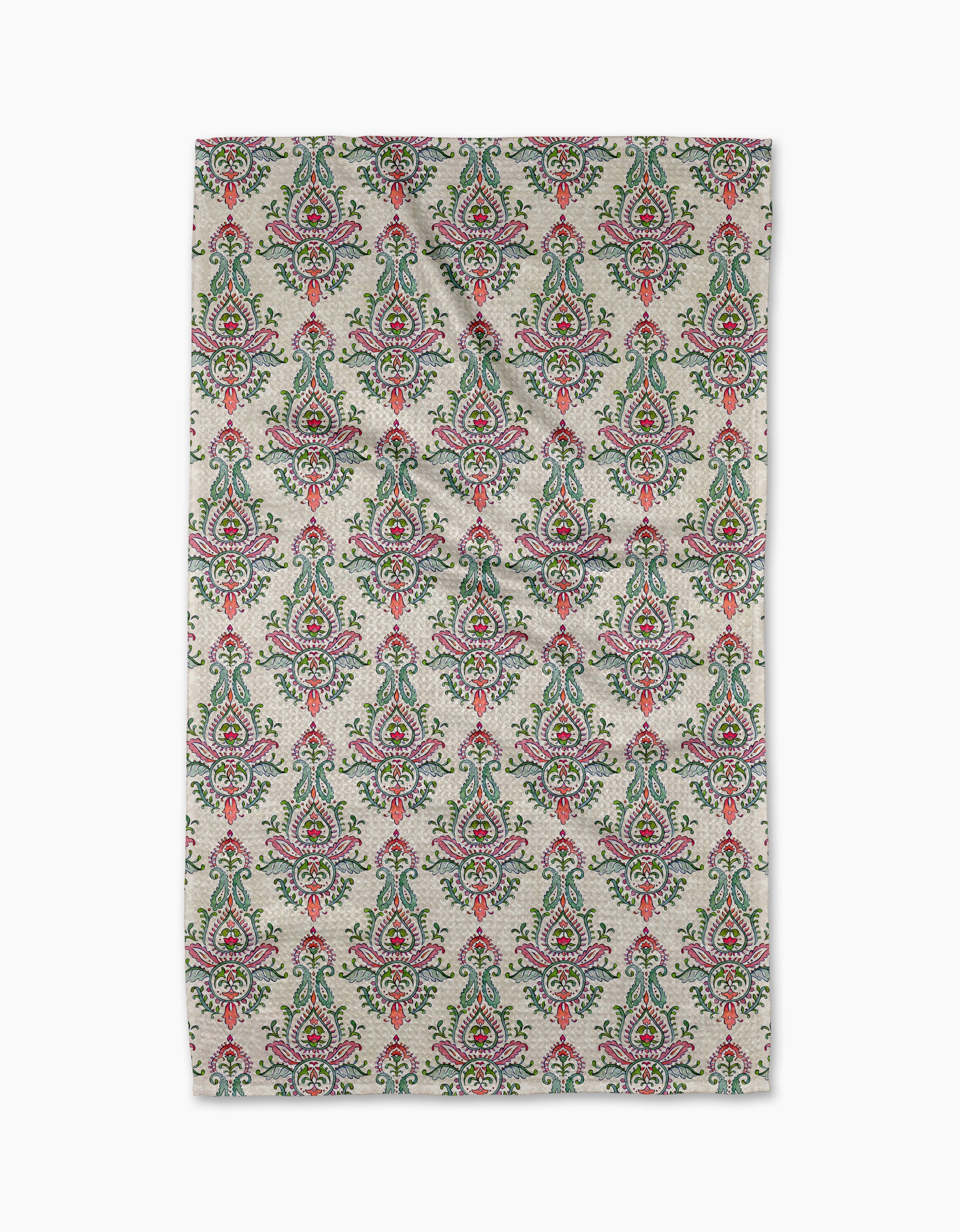 The "Memento" rug by Maayan Alper-Swan features a repeating floral and paisley pattern in green, red, and pink on beige. Made from recycled materials, its symmetrical motifs are arranged in neat rows for a refined look.