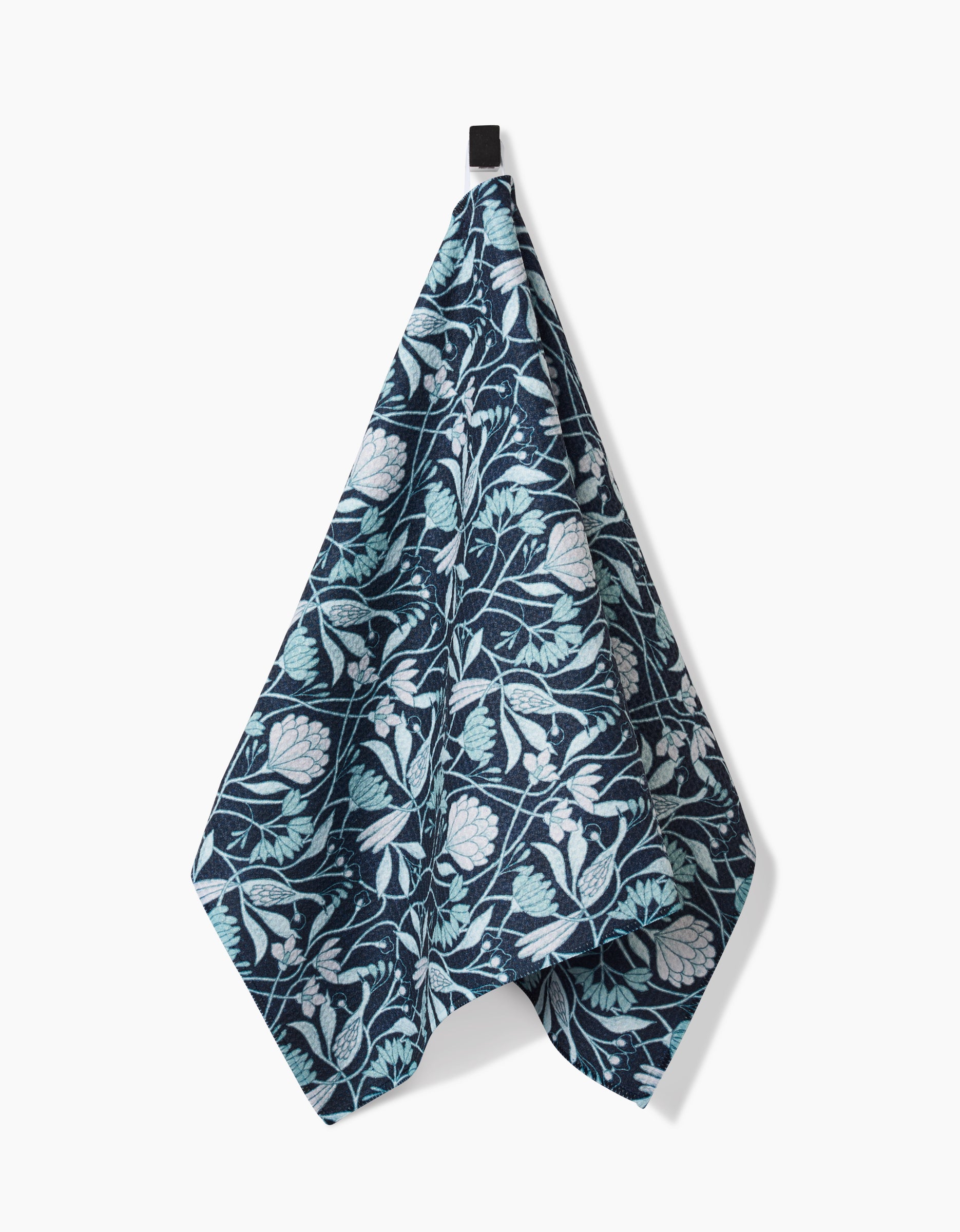 The Mirielle towel by Amy MacCready features a dark blue botanical design with pale green leaves and white flowers, crafted from ultra-absorbent Geoweave fabric and shown against a plain white background.