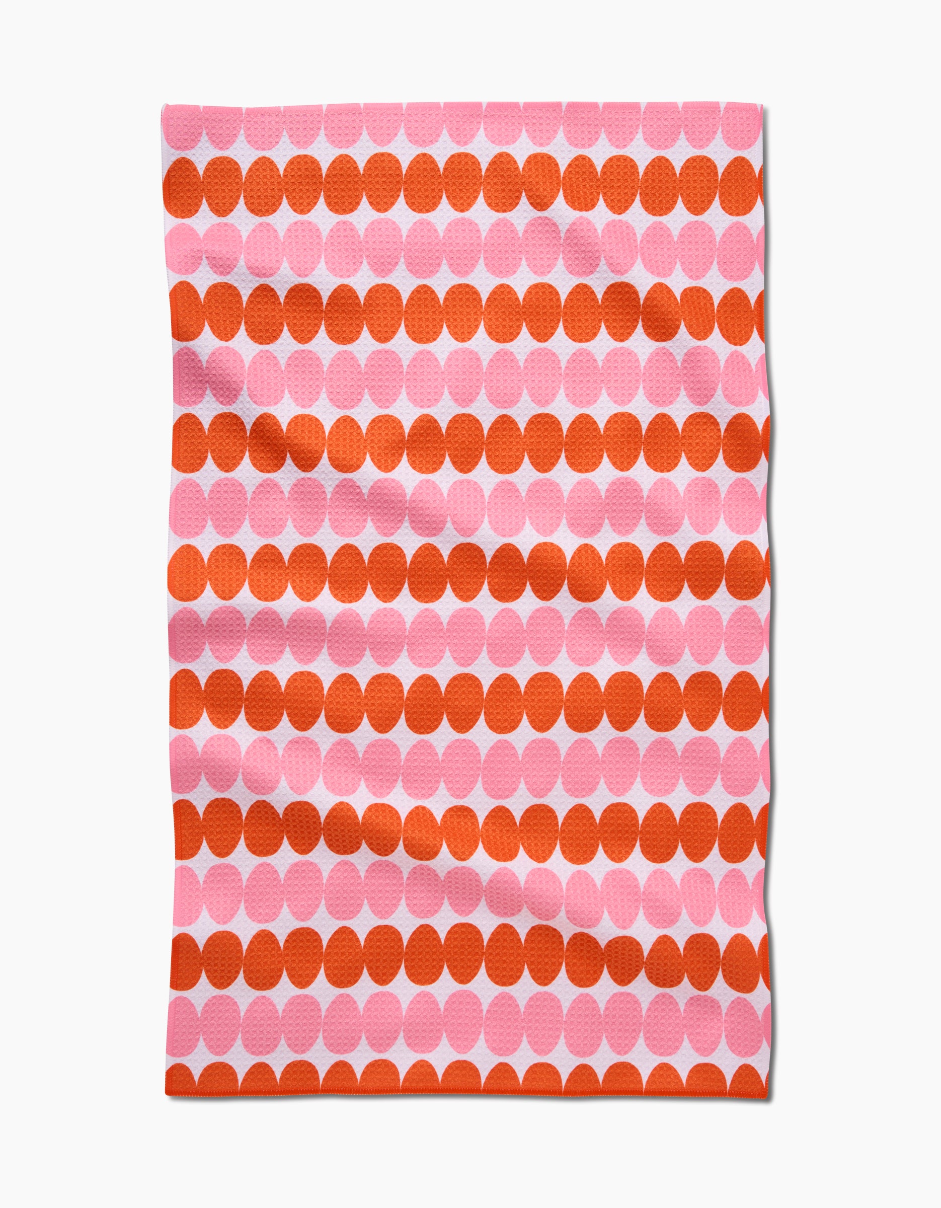 The Kayla Ann Modd Egg is a rectangular Geoweave tea towel featuring large orange and pink geometric dots on a light background. Made from recycled materials, its soft wrinkles create a relaxed, modern look.