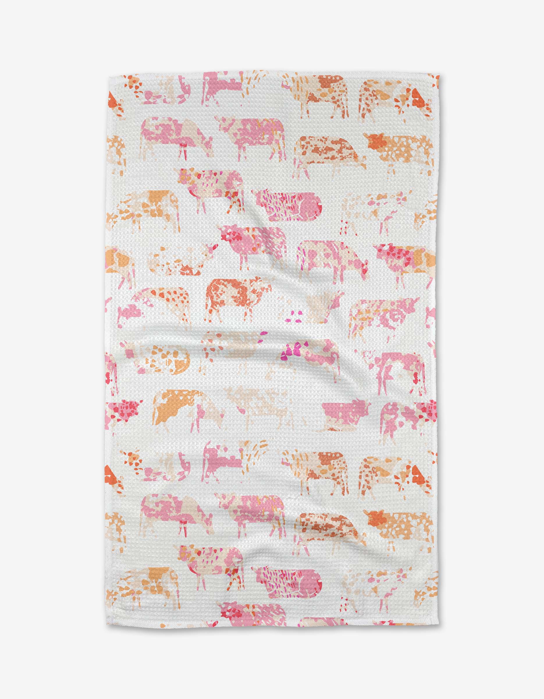 The Elisabeth Wing Moods tea towel is crafted from recycled materials and lays flat with slight wrinkles, showcasing a white base with cows in repeating pink, orange, and peach patterns.