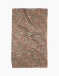 The Moonlight Beta tea towel by Elisabeth Wing is rectangular, made from recycled materials, and features abstract, flowing brown and pink lines and shapes. It’s shown laid flat with gentle wrinkles on a white background.