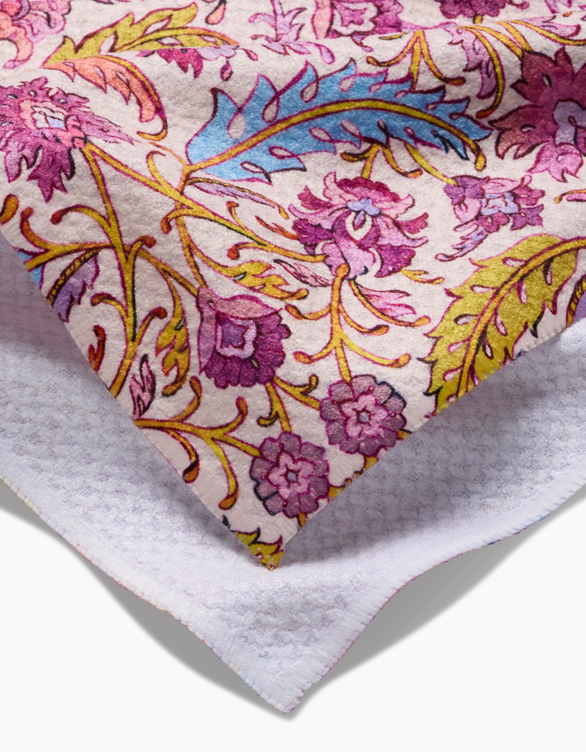 A close-up of the Maayan Alper-Swan Morning Glory Tea Towel, showcasing a vibrant floral pattern in purple, blue, and yellow on a white textured Geoweave fabric.