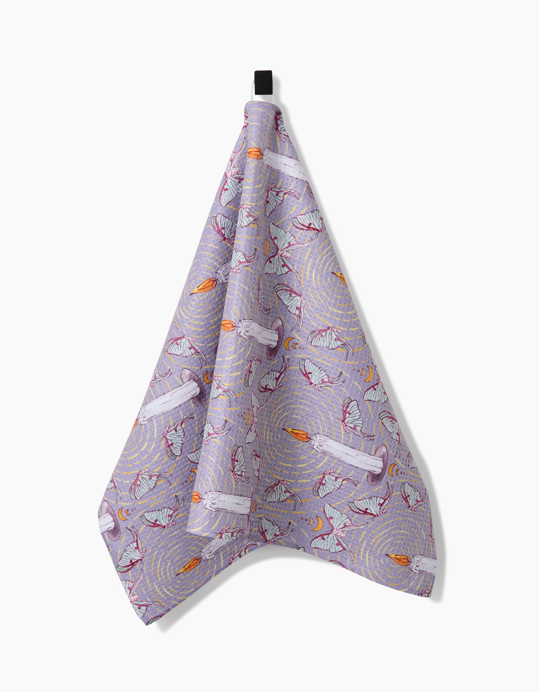 The Moth To A Flame tea towel by Maayan Alper-Swan, made from recycled lavender fabric, showcases playful white cats with yarn on a whimsical print and hangs from a black loop against a white background.